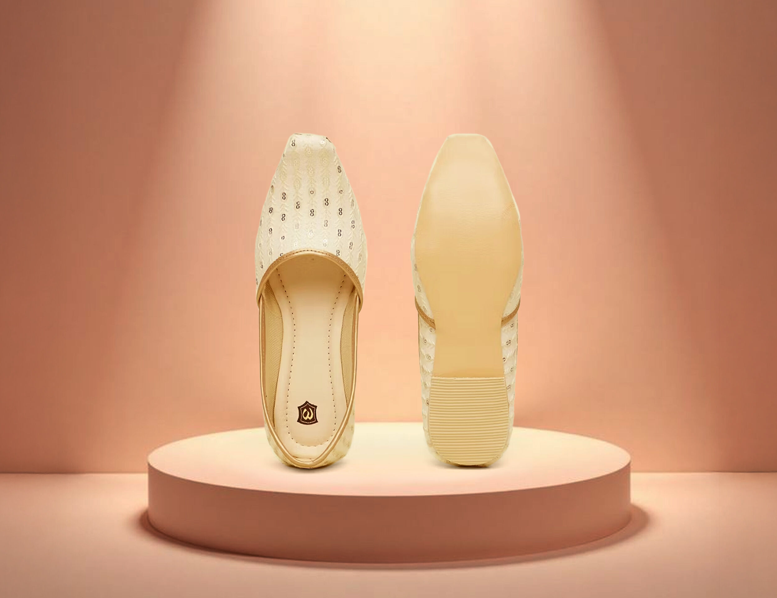 Elegant cream embroidered juttis for wedding, traditional ethnic footwear for men on spotlight podium.